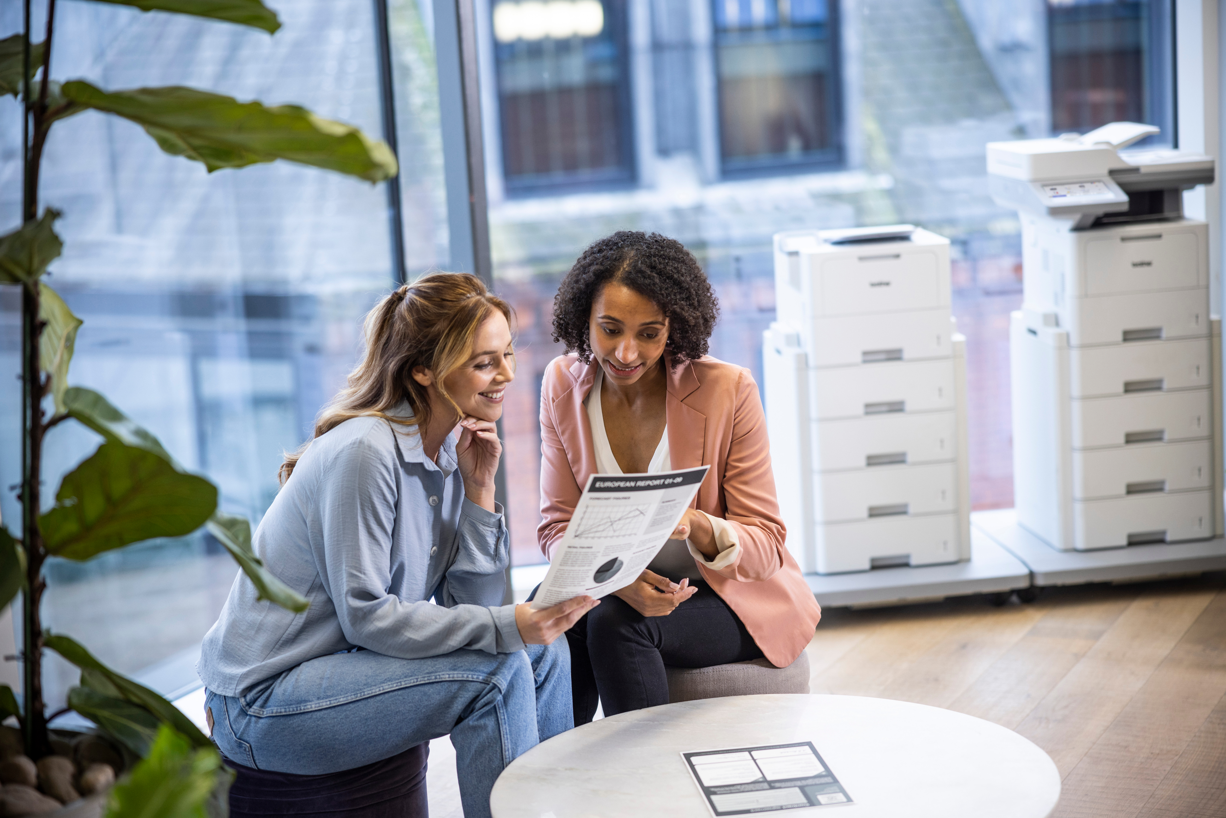 Two people discussing printer options in an office setting
